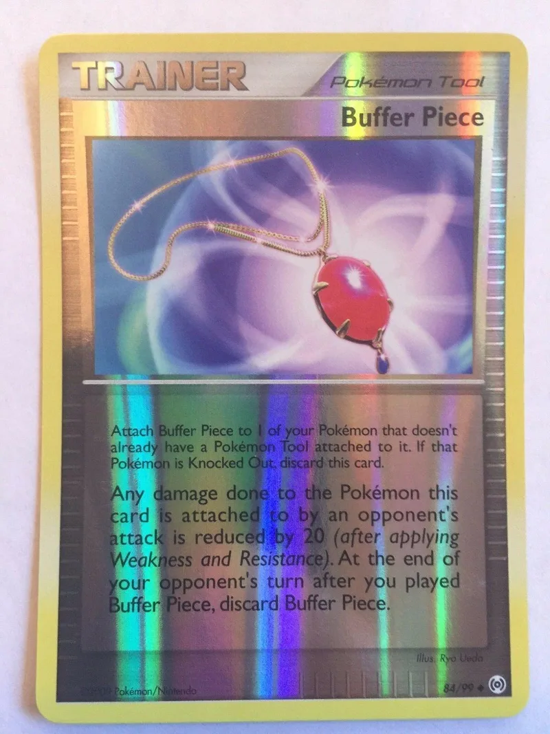 Shiny red pendant on a Pokémon Trainer card. Yellow and purple hues.