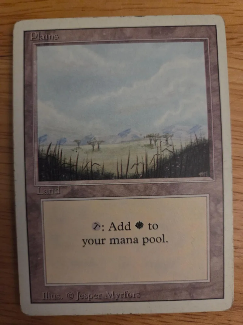 Plain land card art showing a grassy field under a cloudy sky.